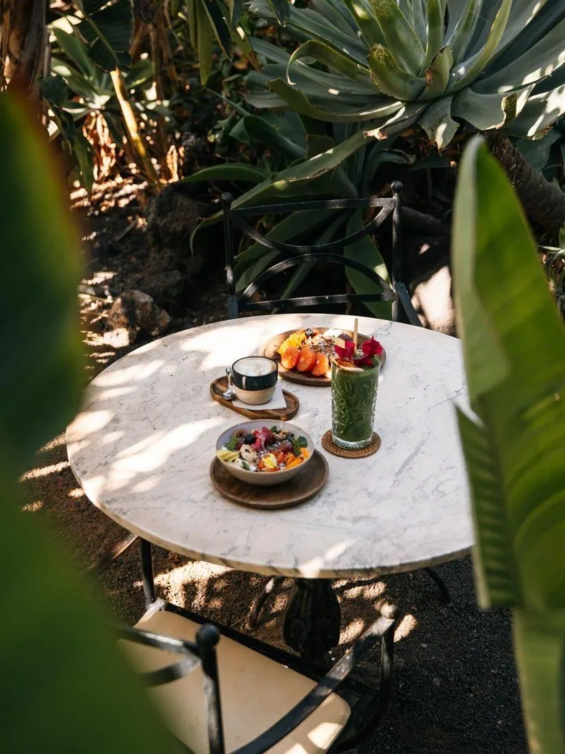 Mesa en el jardín con fruta y una bebida verde, antes